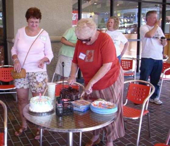 KathieI cutting the cake while VillageKid supervises